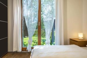 a bedroom with a bed and a large window at Ferienhaus Am Heidenbach in Deggenhausertal
