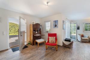 a living room with a red chair and a table at Ferienwohnung Weitblick in Sasbachwalden