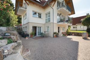 a large white house with a stone wall at Ferienwohnung Weitblick in Sasbachwalden