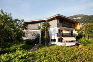 an apartment building with a palm tree in front of it at Julia's Guesthouse in Auer