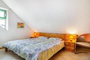 a bedroom with a bed and two lamps and a chair at Bodenseeblick in Meersburg
