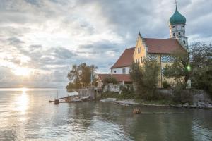 a church on the shore of a body of water at Bodenseeblick in Meersburg