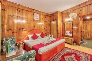 a bedroom with a bed in a room with wooden walls at MHA hotel ever green manali in Manāli