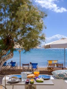 a table with food and a view of the ocean at Echinousa Kimolos Maisonette no1 in Kimolos