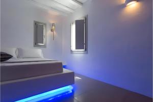 a bedroom with a bed with blue lights on the floor at Echinousa Kimolos Maisonette no1 in Kimolos +9 photos