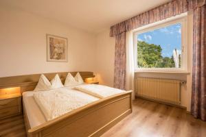 a bedroom with a bed and a large window at Residence Kronstein - Fewo 2 in Tesimo