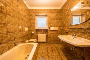 a bathroom with a tub and a sink and a toilet at Residence Kronstein - Fewo 2 in Tesimo +11 photos