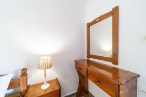 a bedroom with a mirror and a lamp on a dresser at Arianna Studio Ground Floor 7 in Paleokastritsa +16 photos