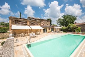 a swimming pool in front of a house at Brotes Appartamento Mandorlo in Sovicille