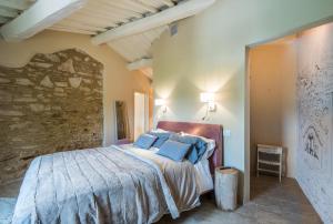 a bedroom with a large bed with blue pillows at Brotes Appartamento Mandorlo in Sovicille