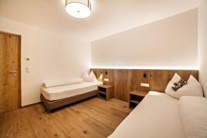 a hotel room with two beds and a desk at Flatschhof - Apartment Vermoi in Kastelbell-Tschars