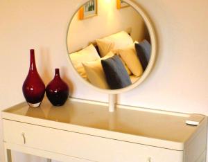 a mirror on top of a dresser with pillows at Solveigs Ferienwohnung in Bad Münstereifel