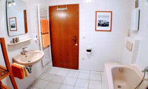 a white bathroom with a sink and a toilet at Solveigs Ferienwohnung in Bad Münstereifel +10 photos