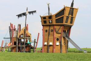 a wooden play structure in a field at Ferienhaus Nixe7 in Dorum Neufeld