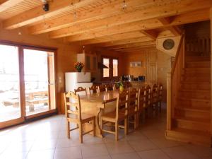 a dining room with a wooden table and chairs at Deux grands chalets communicants in Les Orres