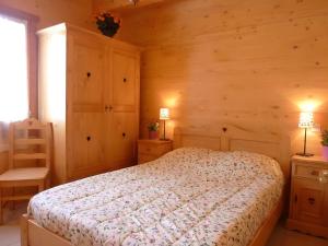 a bedroom with a bed in a wooden room at Deux grands chalets communicants in Les Orres