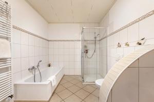 a white bathroom with a tub and a shower at Fewo Lora in Blankenrath +24 photos