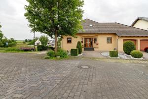 a house with a tree and a brick driveway at Fewo Lora in Blankenrath