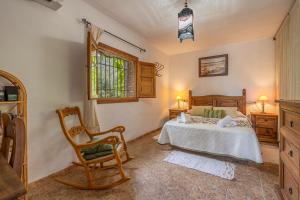 a bedroom with a bed and a chair at La Terrera in Órgiva +22 photos