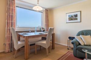a dining room with a table and chairs and a window at Sylter Residenz Westerland in Westerland