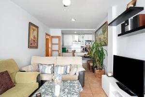 a living room with a couch and a tv at Mirador del Palmar in Conil de la Frontera
