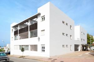 a white building with balconies on a street at Mirador del Palmar in Conil de la Frontera