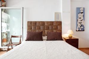 a bedroom with a large bed and a chair at Mirador del Palmar in Conil de la Frontera