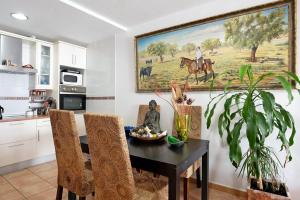 a kitchen with a table and a painting on the wall at Mirador del Palmar in Conil de la Frontera