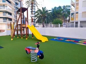 a playground with a slide and a swing set at Nereidas Beachfront in Cullera