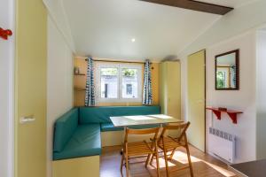 a dining room with a table and chairs at Mobilhome Le Tilleul in Saint-Pompont