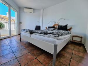 a bed in a room with a large window at Beach panorama Caleta in Caleta De Velez
