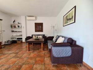 a living room with a couch and a table at Beach panorama Caleta in Caleta De Velez