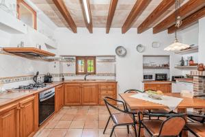 a kitchen with wooden cabinets and a table with chairs at Ca S'hereu in Felanitx