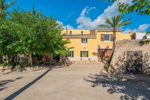a yellow house with a palm tree in front of it at Ca S'hereu in Felanitx