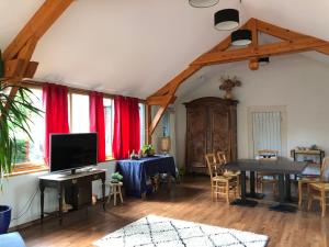 a living room with a table and red curtains at Le Kiosque de Compostelle in Espaly-Saint-Marcel