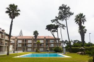 ein Resort mit Swimmingpool und Palmen in der Unterkunft Fão Apart Vacation Apartments in Fão