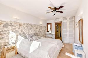a bedroom with a bed and a stone wall at Casa Maria Angela in Artá