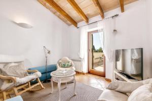 a living room with a couch and chairs and a tv at Casa Maria Angela in Artá