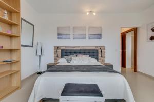 a white bedroom with a large bed and a shelf at Villa Kodotoma in Yaiza +17 photos