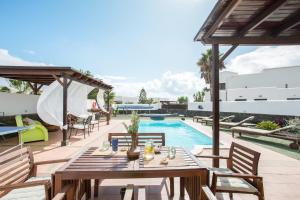 a patio with a table and chairs next to a pool at Villa Kodotoma in Yaiza