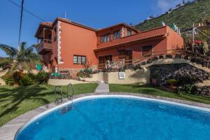 a villa with a swimming pool in front of a house at Casa Victor - Apartment 4 in La Orotava