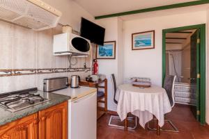 a kitchen with a table and a stove top oven at Casa Victor - Apartment 4 in La Orotava