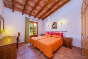 a bedroom with a bed with an orange bedspread at Taconera in Artá +34 photos