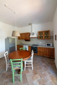 a kitchen with a wooden table and chairs and a kitchen with a refrigerator at Il Cisto in Marciana +28 photos