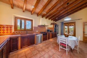 a kitchen with wooden ceilings and a table and chairs at Taconera in Artá