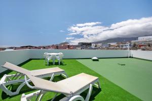 a patio with chairs and tables on a roof at Casa Fefa in Candelaria