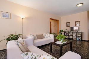 a living room with two white couches and a table at Casa Fefa in Candelaria