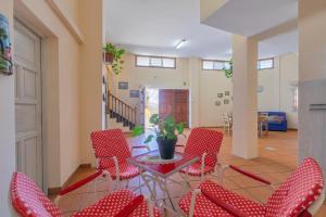 a living room with red chairs and a table at Casa Fefa in Candelaria