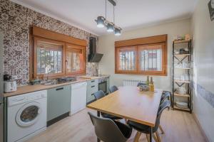 a kitchen with a table and a sink and a dishwasher at El Corcal in Triollo