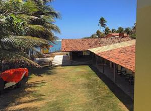 マレシャウ・デオドーロにあるPousada Laguna Marの海の隣の赤い屋根の建物